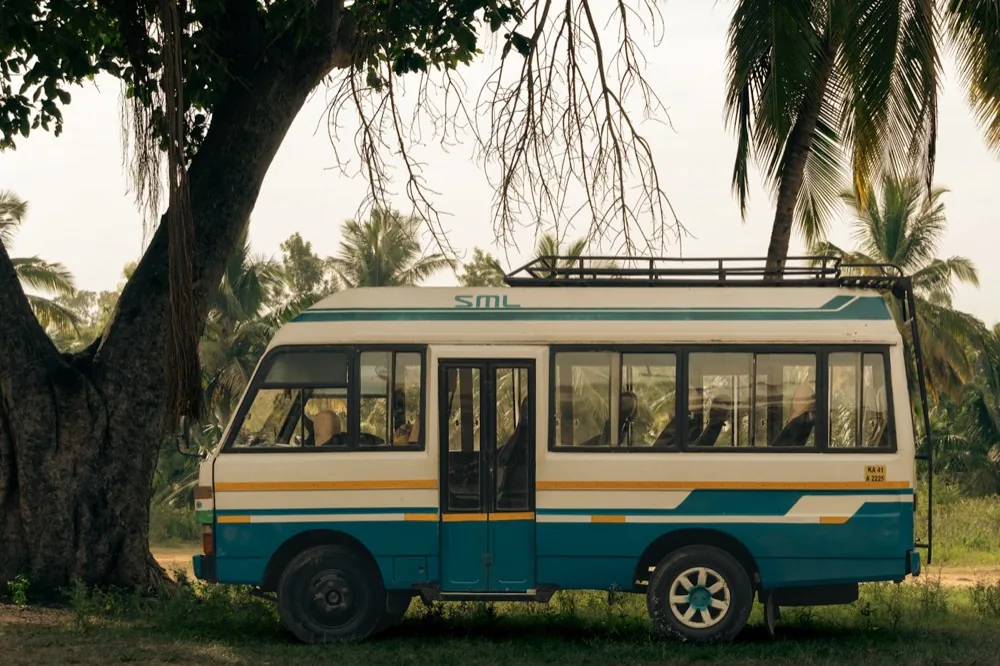 Mini bus from the fleet parked under trees