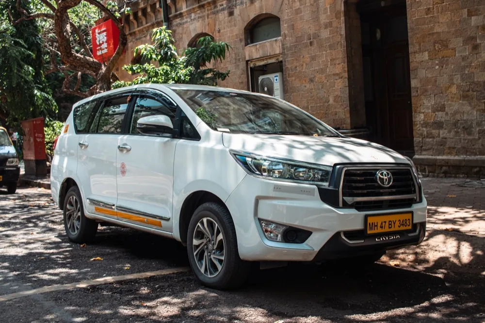 White Toyota Innova Crysta MPV on commercial registration, of the class used for executive duty