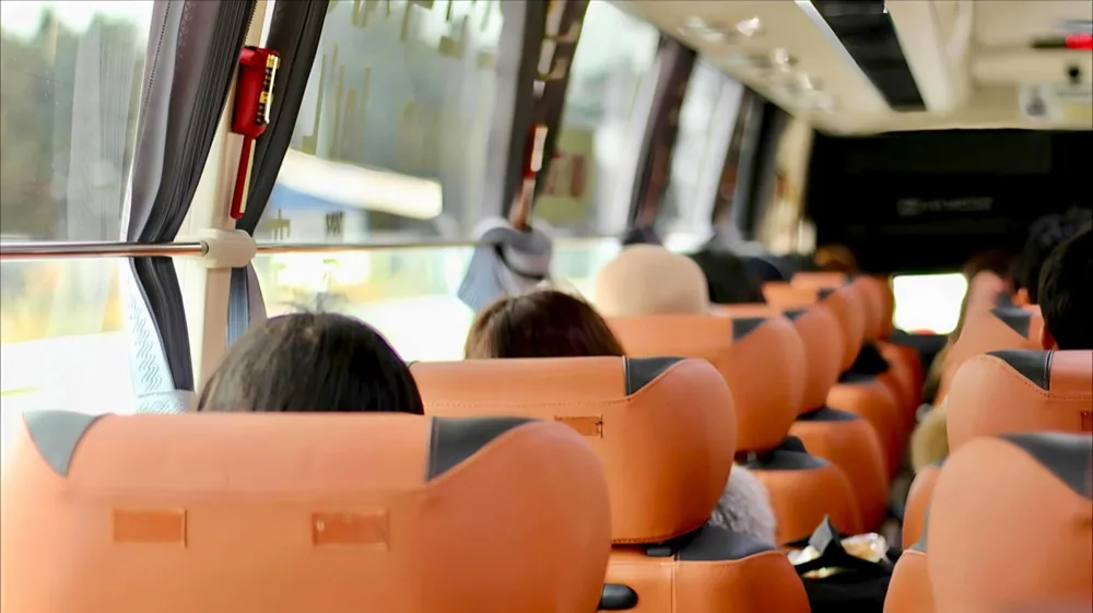 Passengers seated in an air-conditioned coach on a commute run